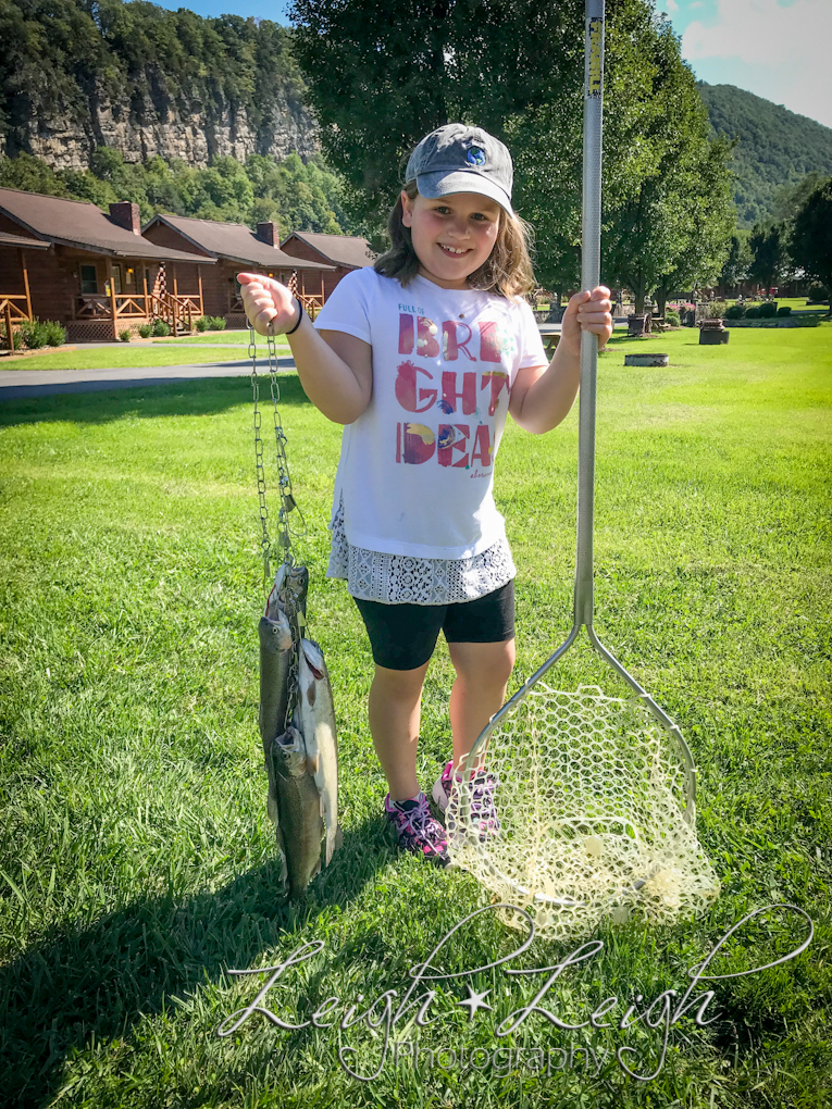 Little girl with a bunch of fish and a net.