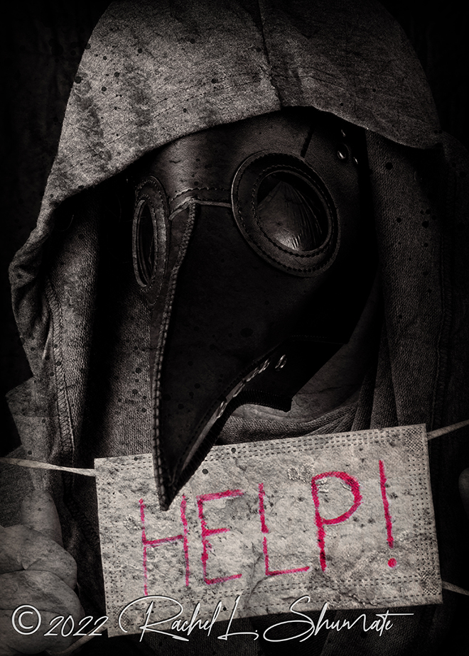 hooded figure with plague mask and facemask that has help written on it