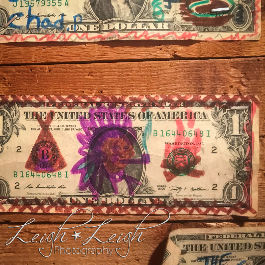 dollar bill on wall with drawings all over it