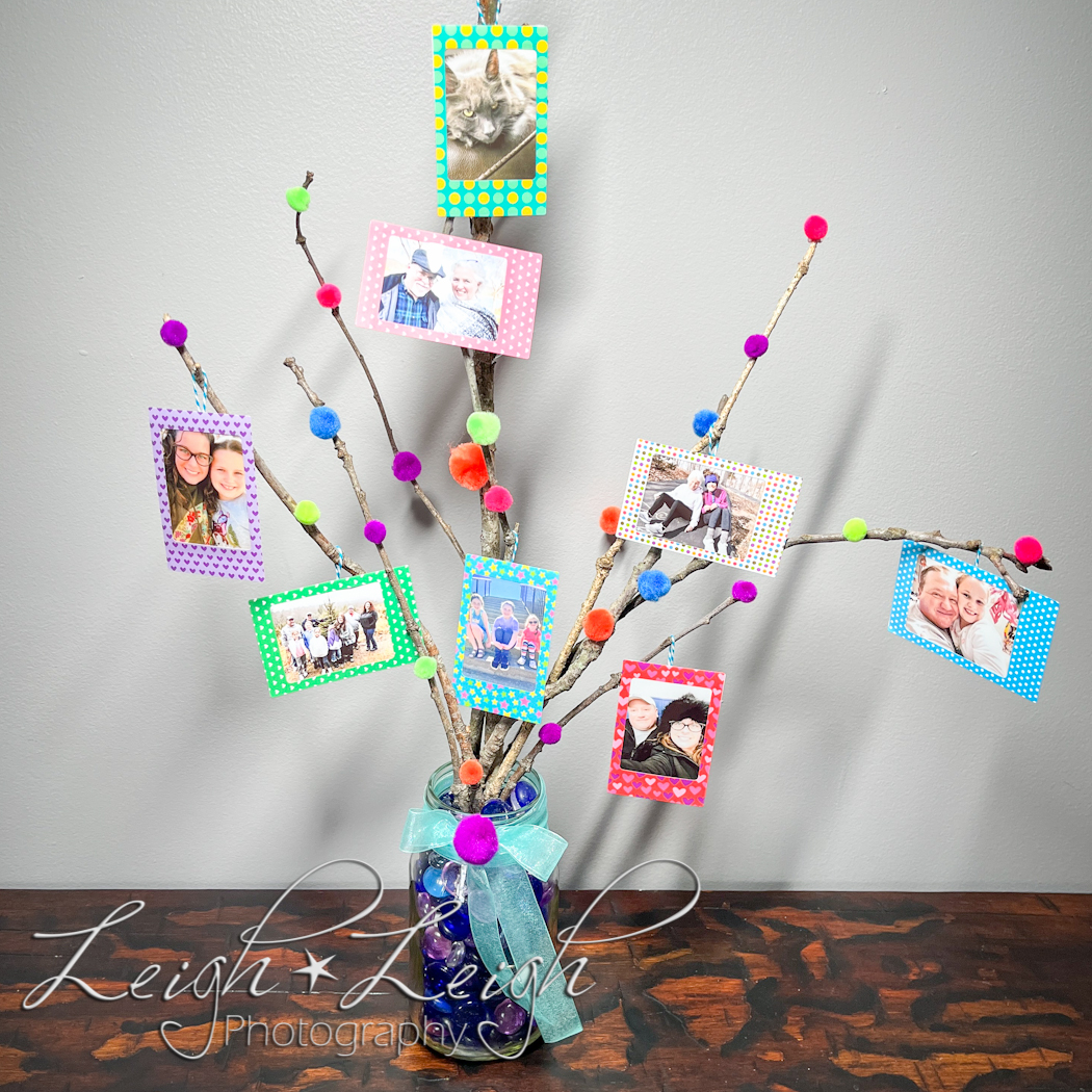 Photo tree made of sticks and small prints as ornaments 