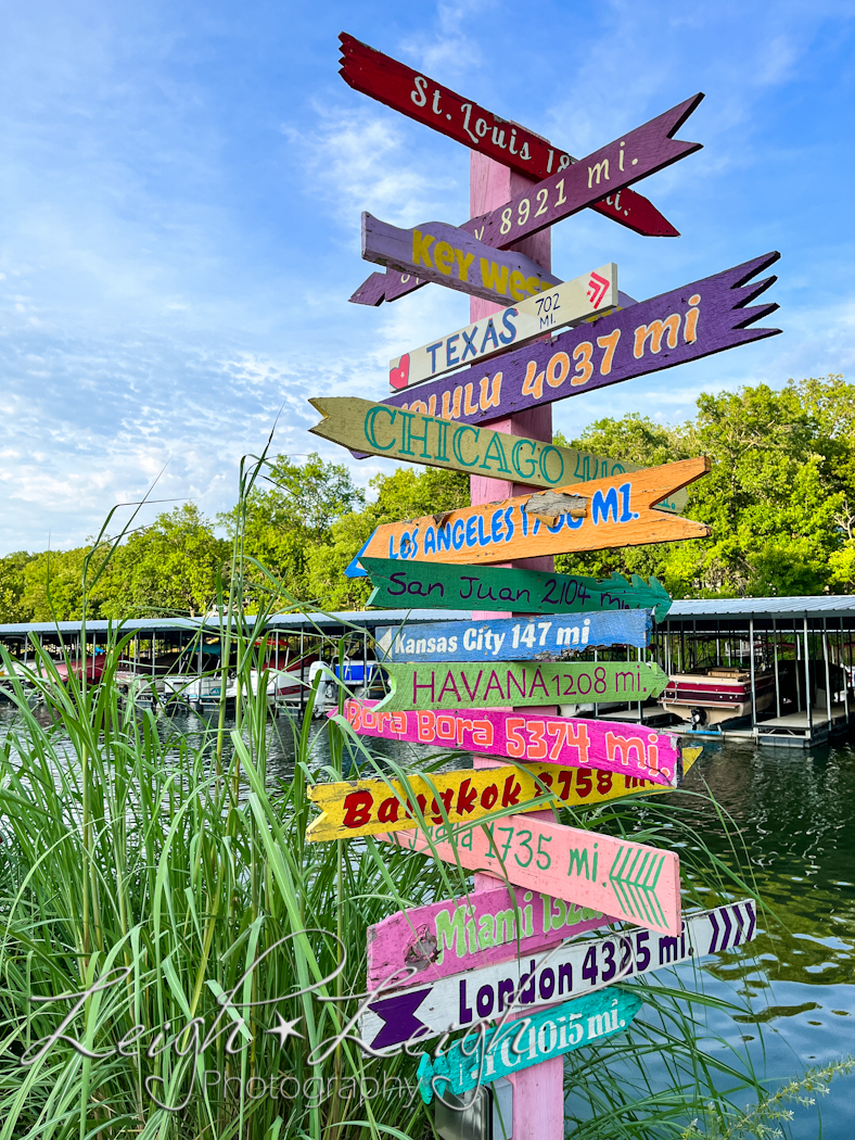 fun signs showing direction and distance to various destinations