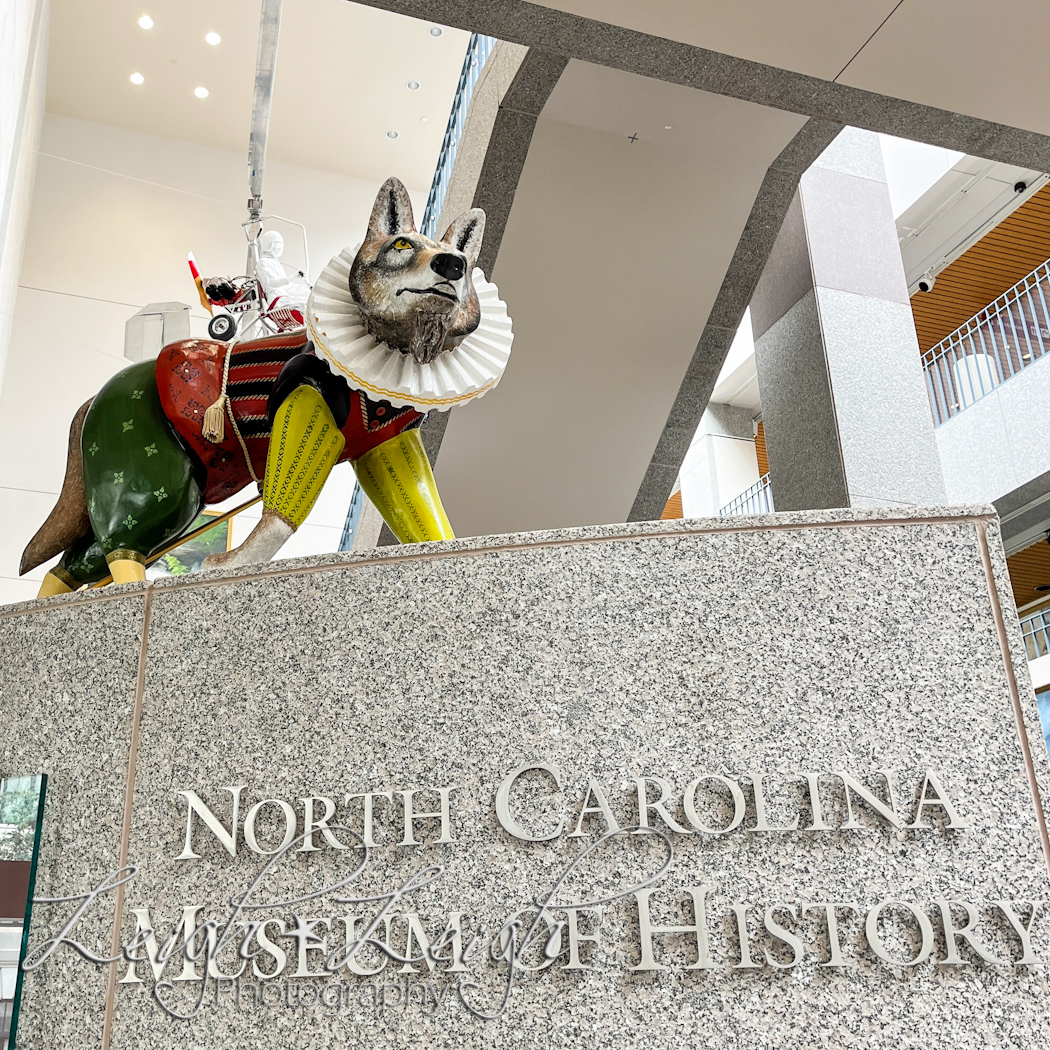 sign for NC museum of history with fun wolf statue on top