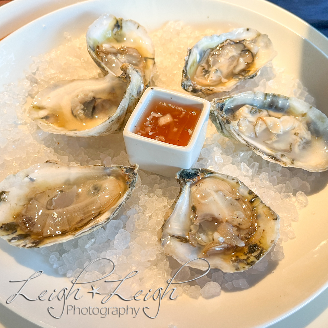 oysters in half shell on iced plate with dipping sauce