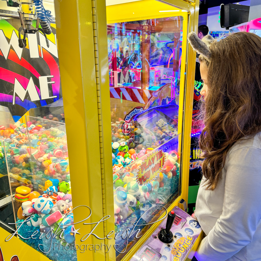 girl playing claw machine in Northern Lights Arcade