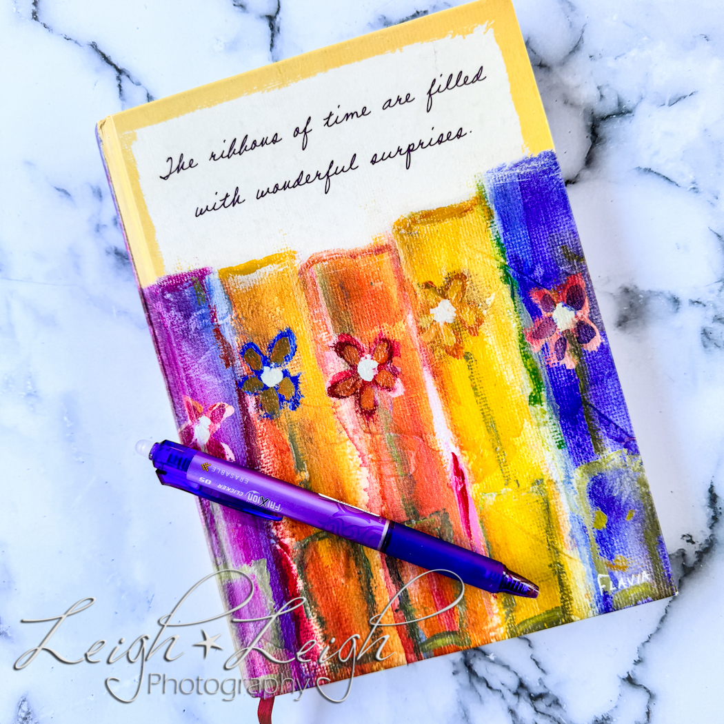 a colorful journal with a purple pen