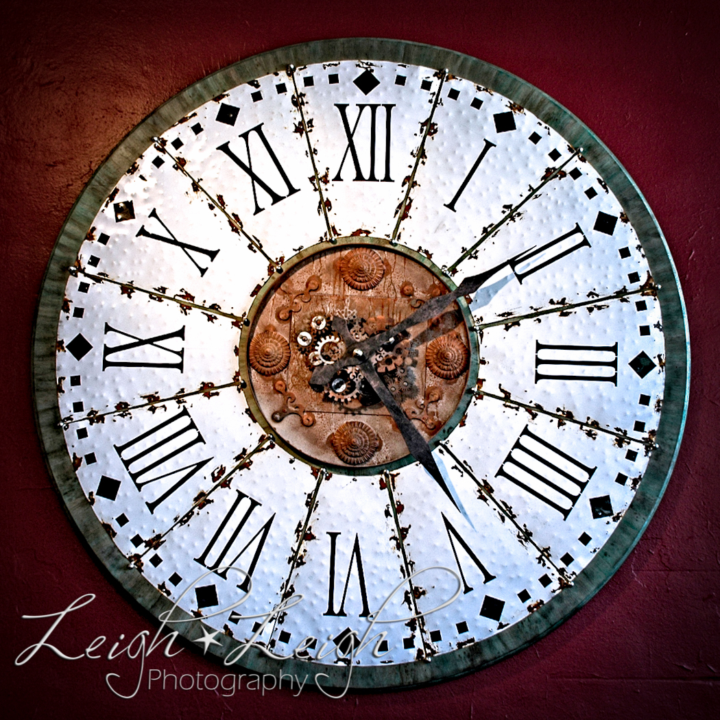 large clock with Roman numerals against a dark red wall