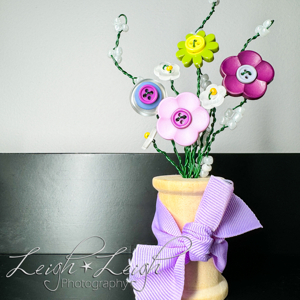 a button bouquet in a spool for a vase