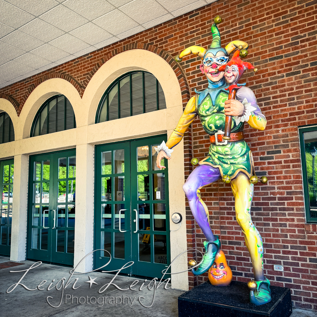 Front doors to Mardi Gras Casino & Resort with statue of a jester 