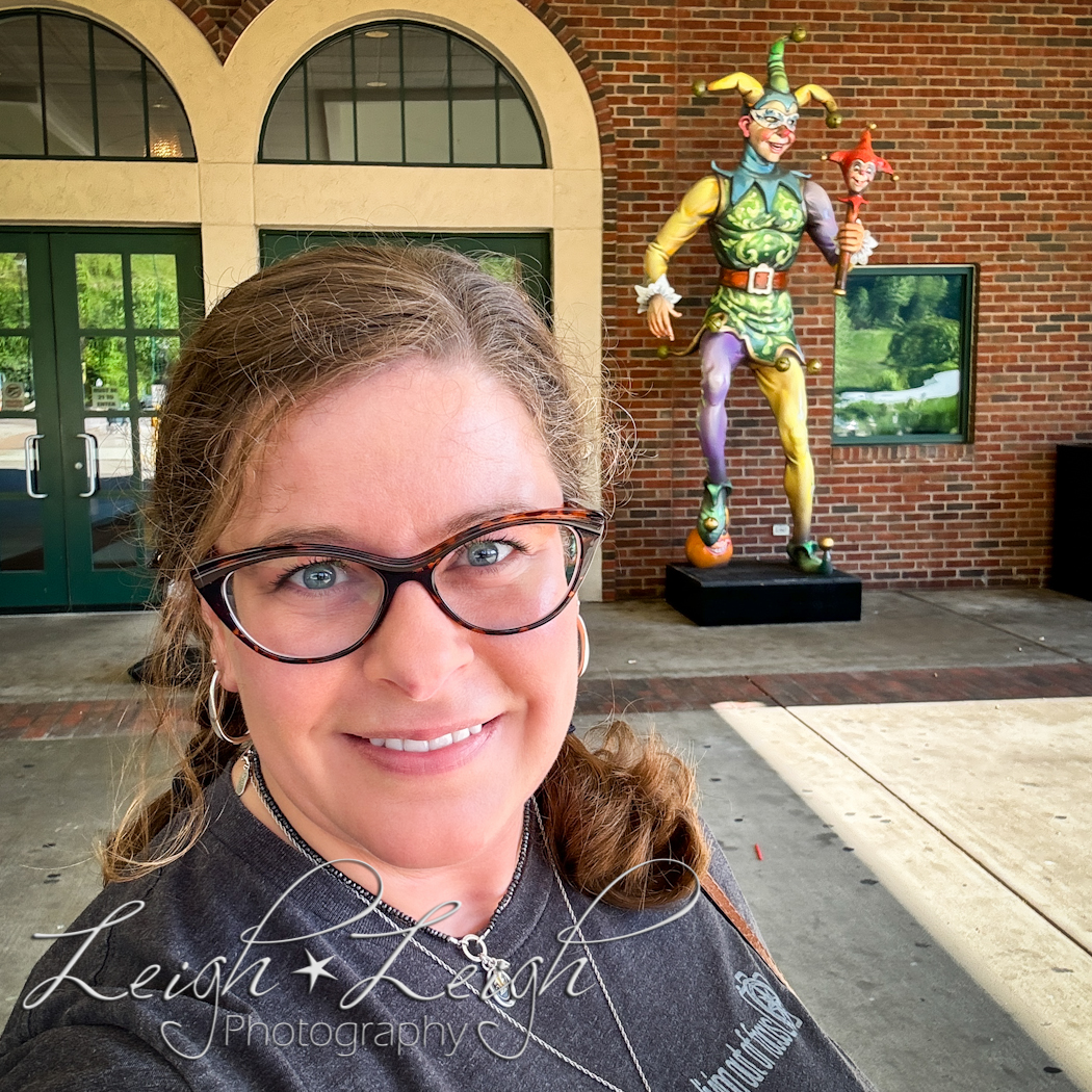 Rachel's selfie by front doors to Mardi Gras Casino & Resort with statue of a jester