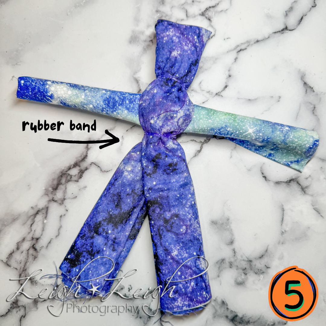 two pieces of fabric with two rubber bands to make body of doll