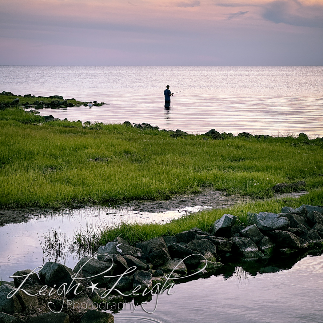 man fishing in sound at sunset