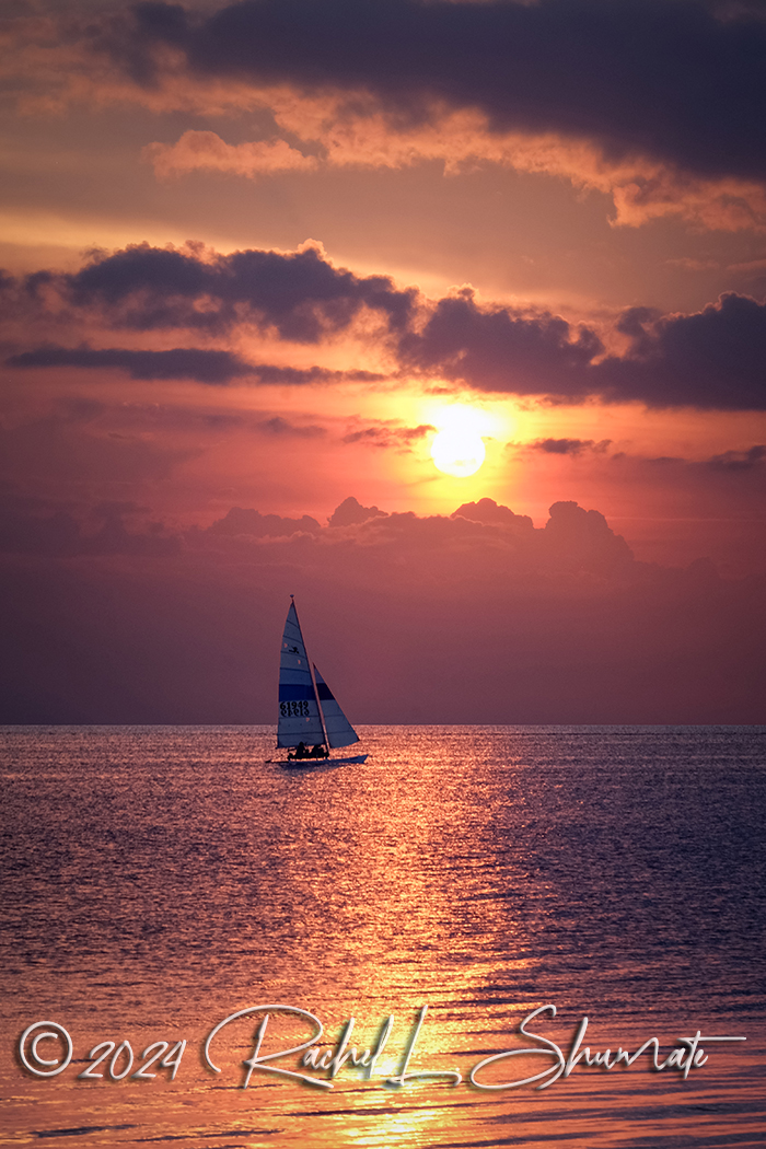 a sailboat on the water during a beautiful sunset