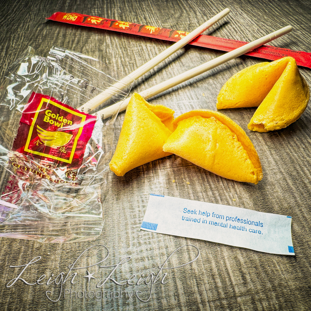 fortune cookies with one open, a fortune, and chopsticks