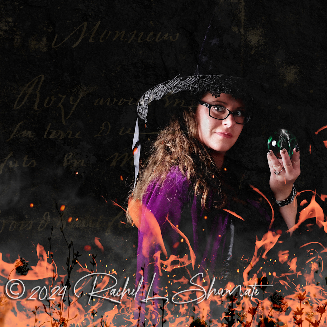 Self portrait of Rachel in a witch costume, holding a crystal ball, surrounded by fire