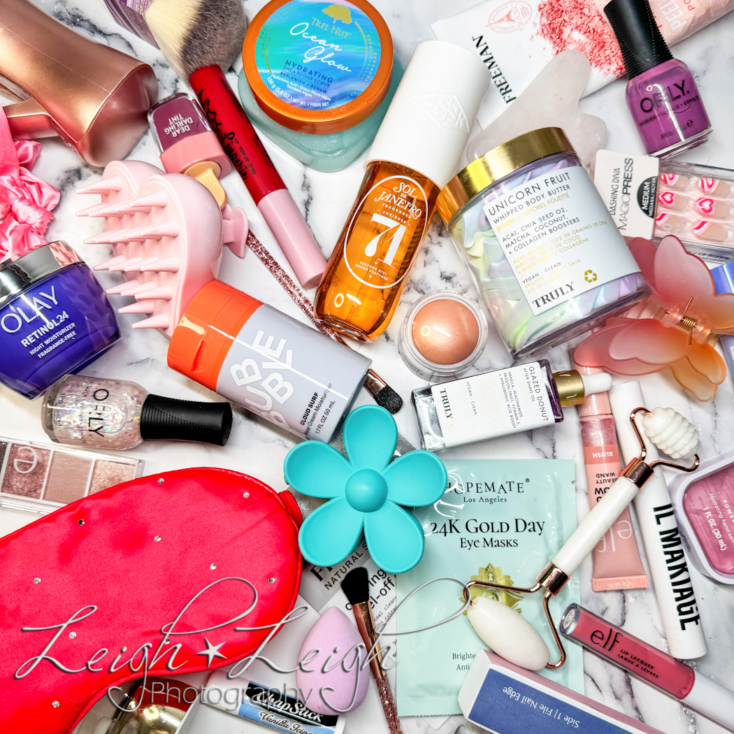 a lay flat image of a bunch of beauty products piled together